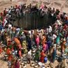 PEOPLE GATHER TO GET WATER FROM A HUGE WELL IN THE VILLAGE OFNATWARGHAD.